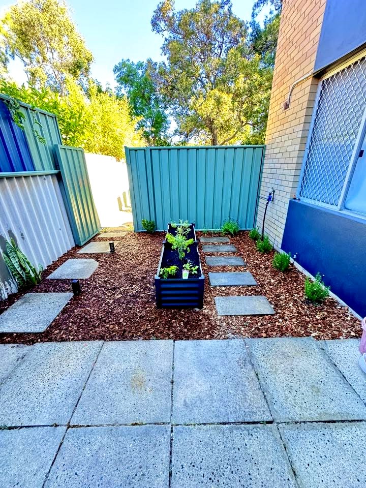 Side yard after cleanup, garden bed with fresh mulch and new plants